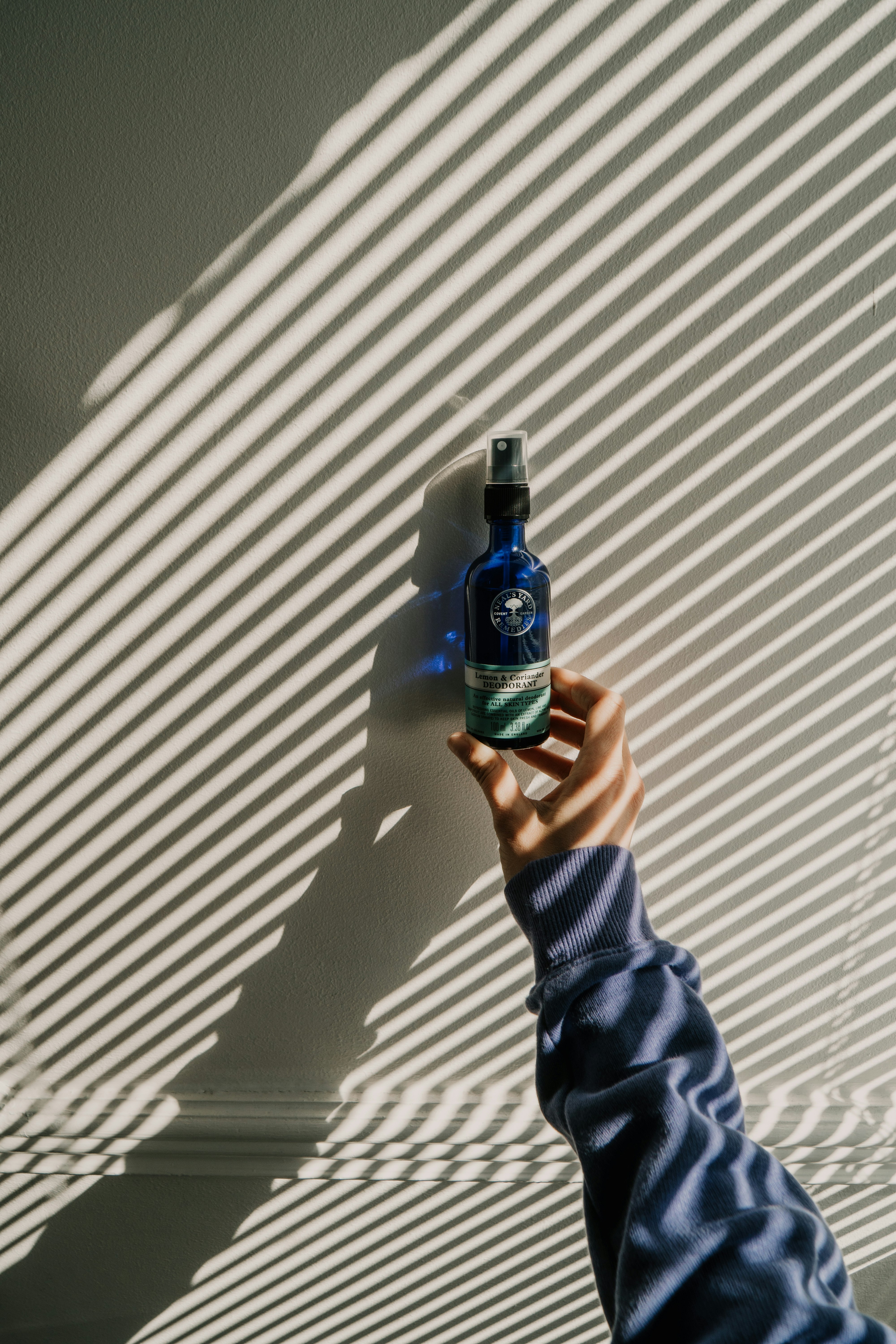 person holding green and black bottle